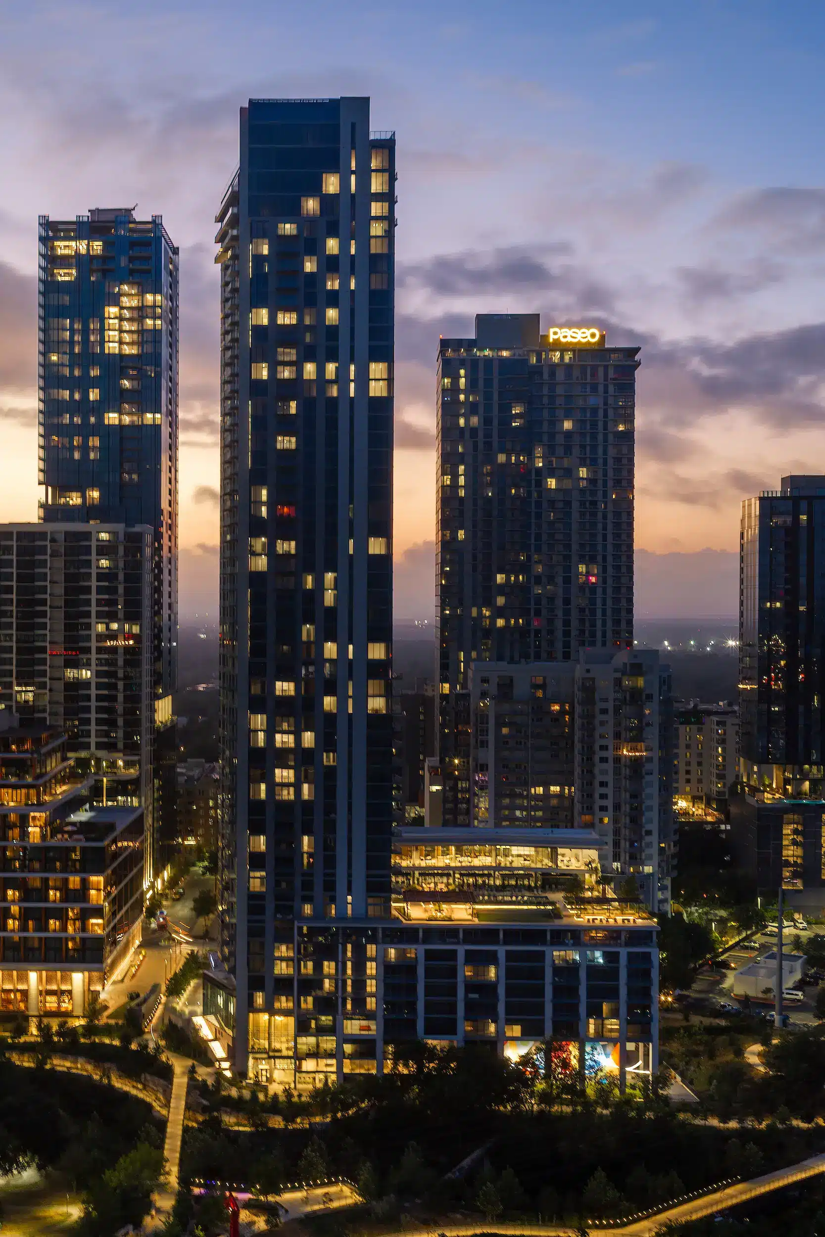 The Travis ATX tower facade in the Austin skyline at twilight