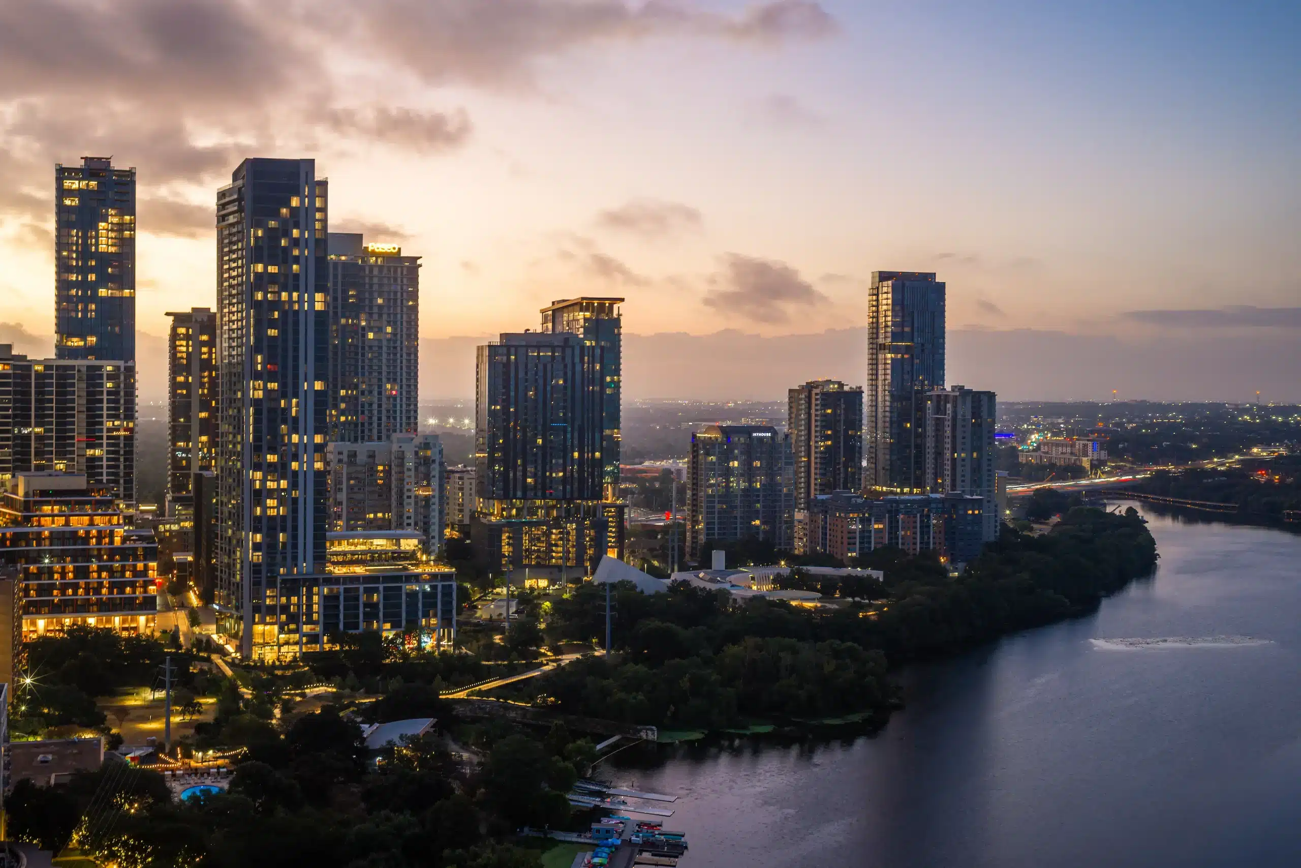 The Travis ATX and neighboring towers beside Lady Bird Lake at twilight
