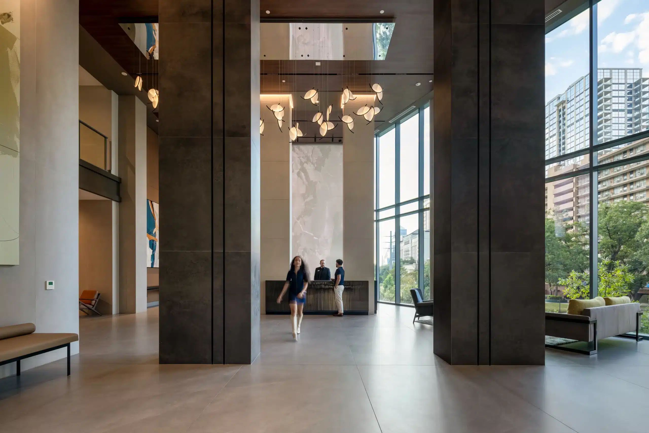 The Travis ATX lobby with stone columns and floor-to-ceiling glazing