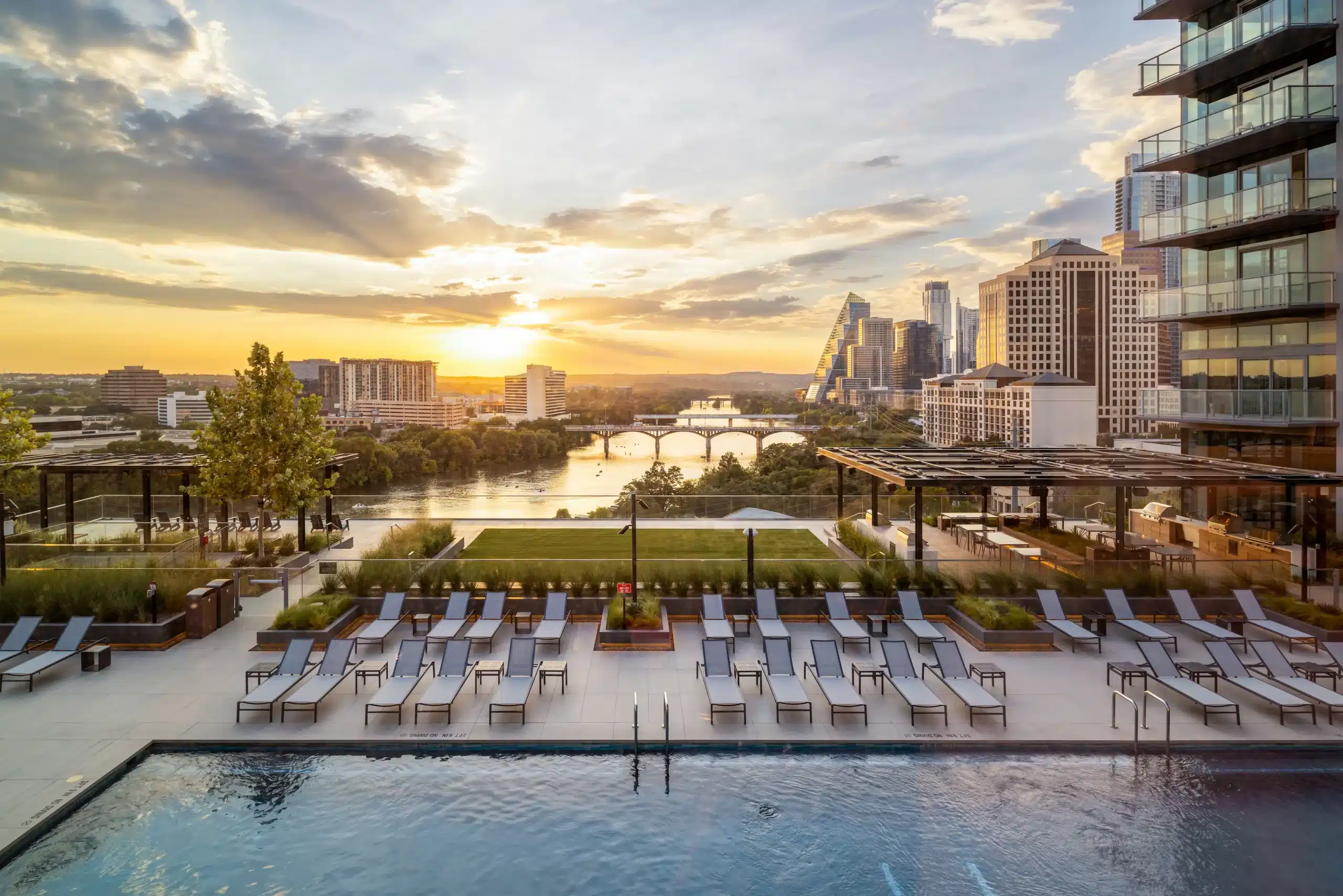 The Travis ATX pool deck overlooking Lady Bird Lake at sunset